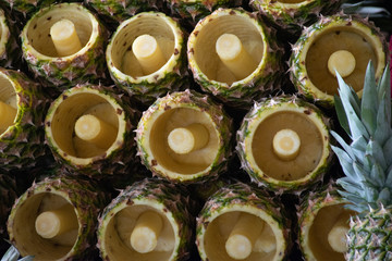 Fresh Peeled Pineapple selling at organic farmers market and showing empty peel
