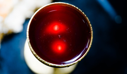 Close up Holy communion on wooden table on church.Taking holy Communion.Cup of glass with red wine, bread.The Feast of Corpus Christi Concept.