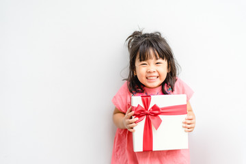 Little asian girl smile and excited and holding red gift box on white background.child holding gift...