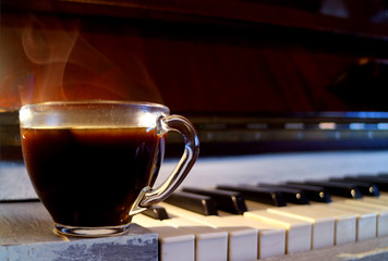 Closeup a cup of hot coffee with smoke on the piano