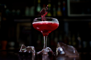 creative red cocktail with splash and berries