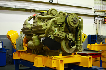 Large diesel engine with a huge turbine in the warehouse of finished products factory for the...