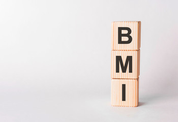 BMI letters of wooden blocks in pillar form on white background, copy space