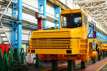 Production process of heavy mining trucks at the factory. Dump truck on the Industrial conveyor in the workshop of an automobile plant. Manufacturer of haulage and earthmoving equipment, haul trucks