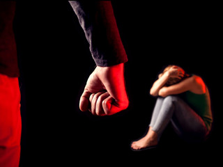 Man shows fist in front of woman. People, family violence and crime concept