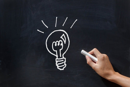 Hand drawing light bulb on the blackboard.Concept of idea,presentation