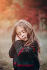 Close up Portrait of cute little girl in autumn forest.