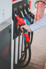 To fill the machine with fuel. Gas station pump. Man filling gasoline fuel in car holding nozzle