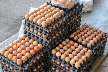 chicken fresh eggs, white and beige, on display in a local farmers market, in order in carton,...