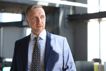 Fototapeta premium Confident pensive mature business man in modern office.