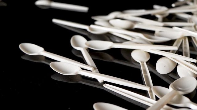 Plastic Spoons Being Thrown On Black Background In Slow Motion. Locked Off