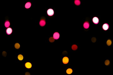 Many soft pink and yellow blurry bokeh light on dark background in Christmas and New Year festival day, can use for background