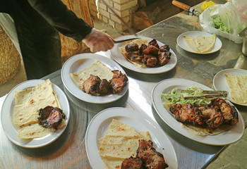 Chef Taking Grilled Pork from Skewer to the Plate Ready for Serving Armenian Barbecue or Khorovats