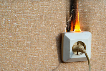 Defective wiring causes a fire. Burning electrical wiring and socket. There are no people at home....