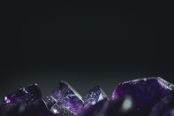 amethyst with light shine on, at the bottom of image with black background