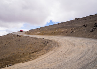 Lunar landscape with winding dirt road in Chimborazo National Park, Ecuador