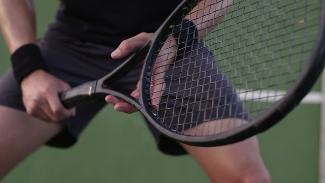 Close up of a tennis player ready to return with his racket. Pro tennis player with his racket during a match.