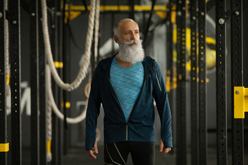 Fit bearded senior man resting after working out.