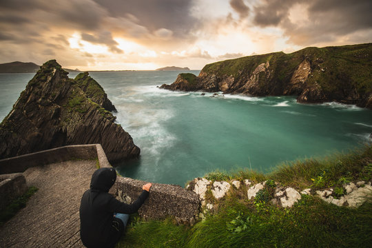 Girl watching over the ocean at the Dunquin Pier situated on the west coast of the Dingle Peninsula in Ireland