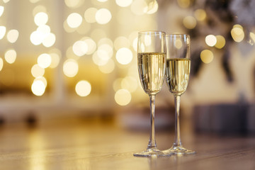 Two glasses of champagne with lights in the background. focus on near glass.