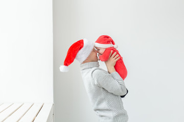 Fatherhood and holidays concept - Father with his baby boy wearing Santa hats celebrating Christmas