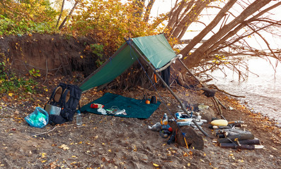 camping tent in autumn in the forest by the river