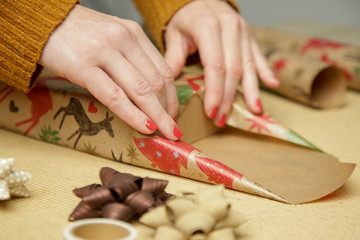 Woman wrapping Christmas presents, winter hoildays,  gifting season concept