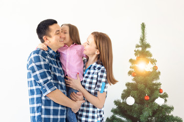 Holidays, gifts and christmas tree concept - Small family having happy time together on Christmas.