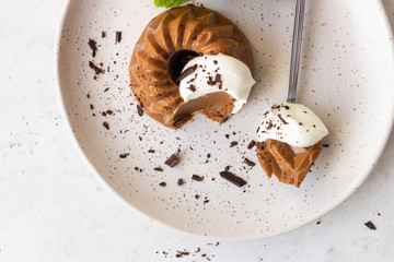 Chocolate dessert decorated with whipped cream, grated chocolate and mint. Traditional Italian dessert panna cotta. Selective focus.