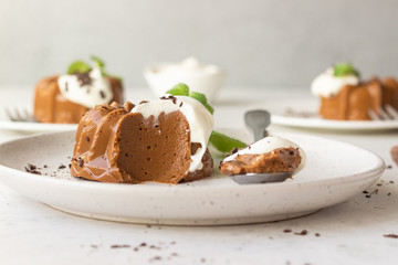 Chocolate dessert decorated with whipped cream, grated chocolate and mint. Traditional Italian dessert panna cotta. Selective focus.