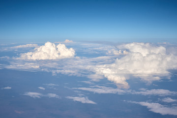 Fototapeta na wymiar Aerial view of fluffy clouds. Top view of a beautiful cloudscape and blue sky