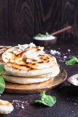 Onion, mint and cheese small flatbreads served on a wooden plate. Gozleme - crispy, golden Turkish flatbreads.