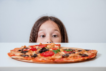 Little brunette girl eating pizza