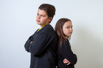 a little girl and a boy stand shoulder to shoulder