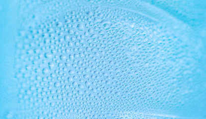 Abstract background close up water drops on blue background in cold bottle.Wallpaper texture background.
