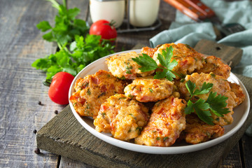 Chicken meatballs with minced meat with tomatoes in a bowl on a wooden rustic table with copy space.