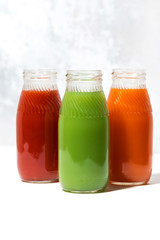 Fototapeta na wymiar colorful vegetable juices in bottles, vertical closeup