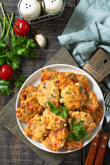 Chicken meatballs with minced meat with tomatoes in a bowl on a wooden rustic table. Top view flat lay background.