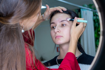 Fototapeta premium Young girl masks pimples in beauty salon