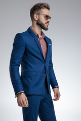 dramatic young model in blue suit wearing sunglasses