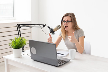 Radio, blogging, podcasting concept - young woman working as a dj on the radio.