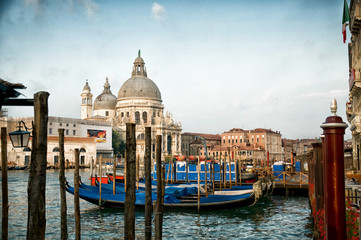 Fototapeta na wymiar Docked Gondolas in Venice, Italy Grand Canal with domed church in background