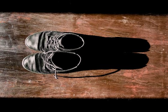 Hi-Top Shoes Casting a Shadow on Wood