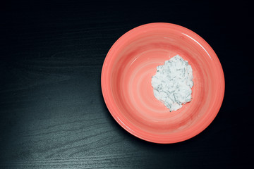 Cheese sauce on a plate on a dark background