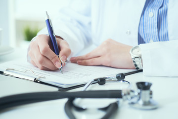 Fototapeta premium Mid section of female doctor writes prescription to patient at worktable. Panacea and life save, prescribing treatment.