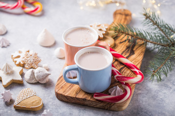 Hot chocolate cacao drinks with gingerbread  in Christmas color mugs on grey background. Traditional hot beverage, festive cocktail at X-mas or New Year