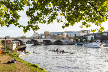 Kingston Upon Thames with the river Thames being used by rowers and motor boats