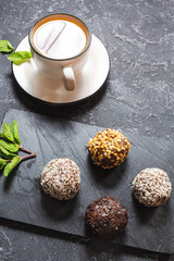 Hot tea cup with mint and sweets on stone background