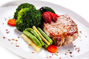 Grilled steak with vegetables on white background