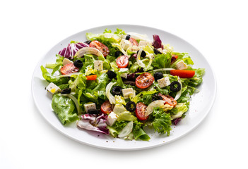 Fresh greek salad on a plate on white background
